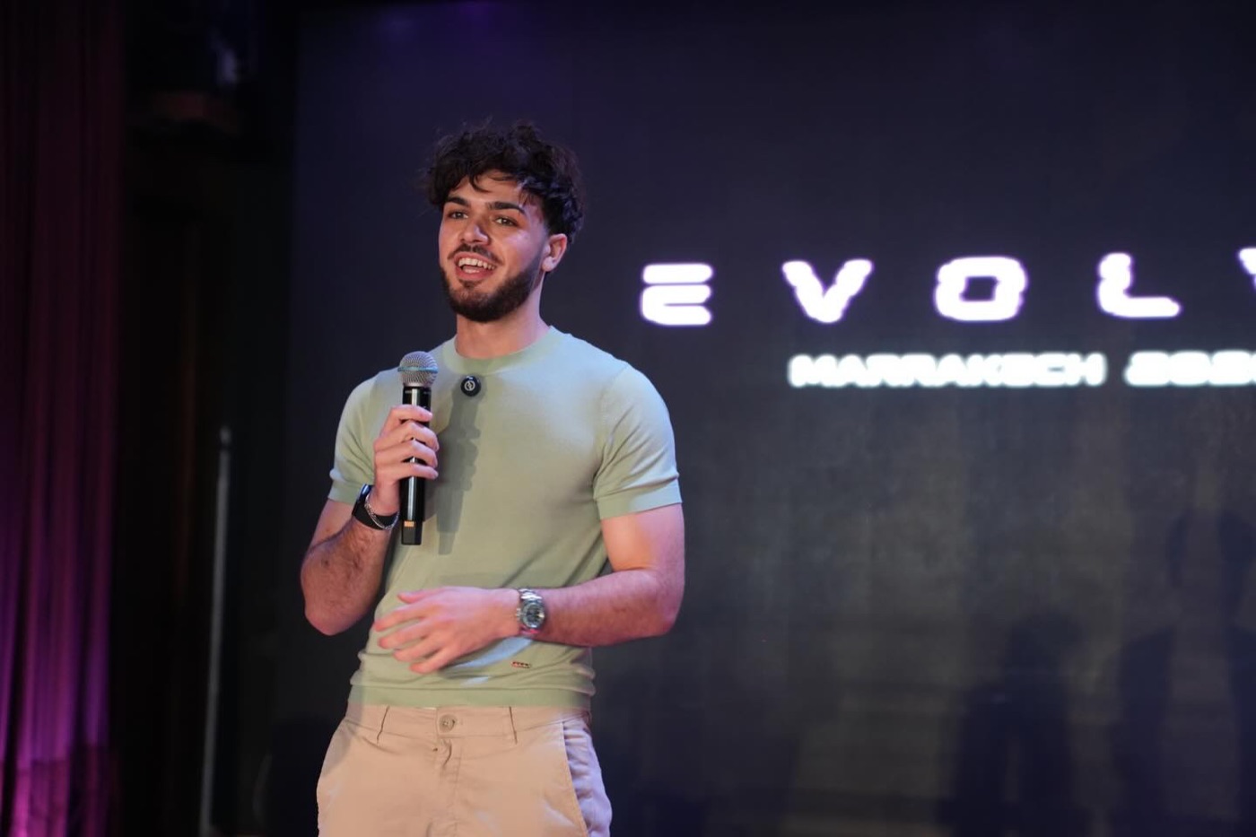 Nicolò speaking on stage with a microphone